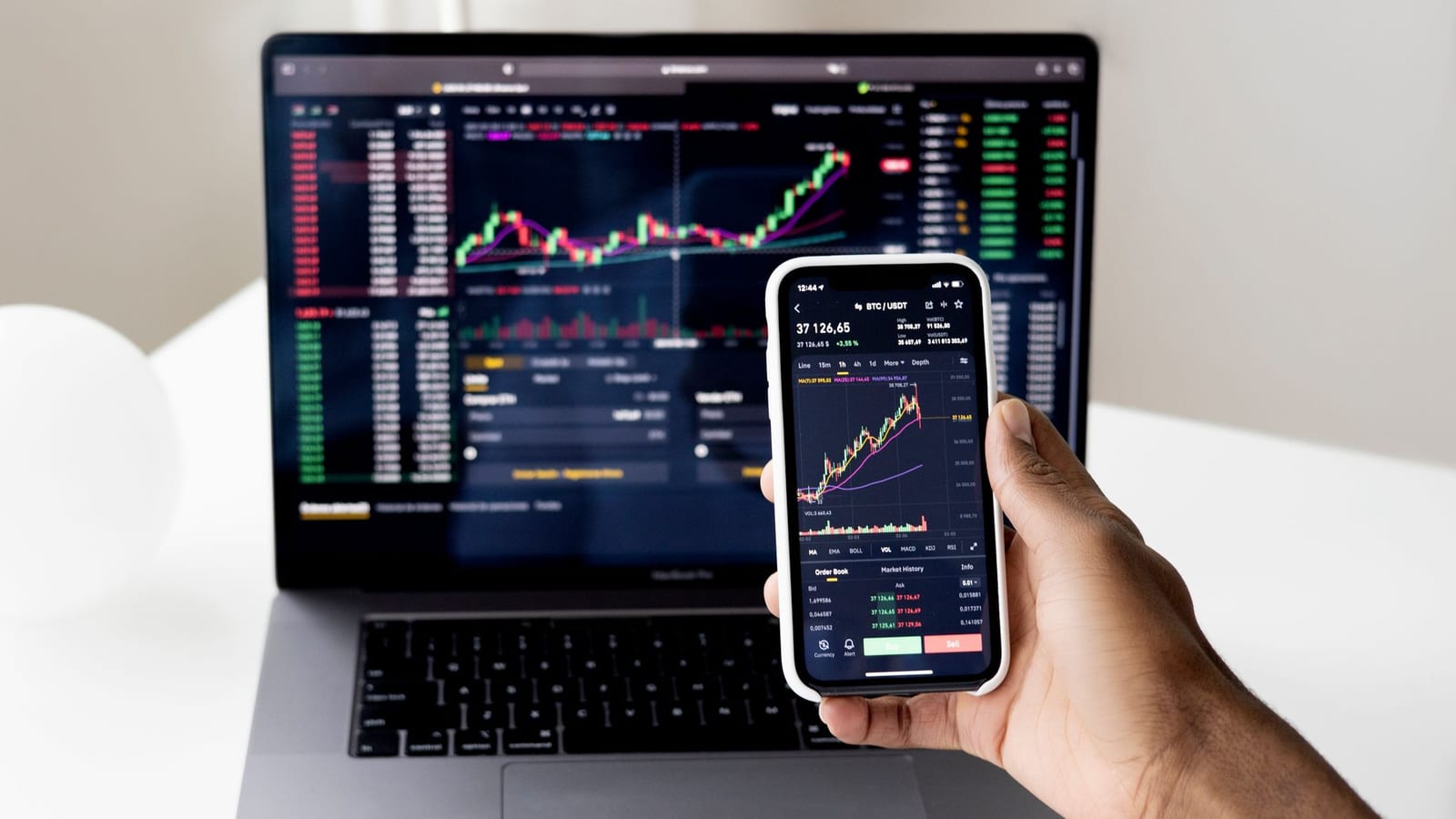 Notebook e celular com gráficos do mercado