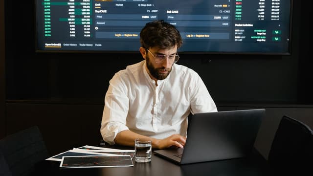 Trader diante de uma grande tela com gráfico do mercado